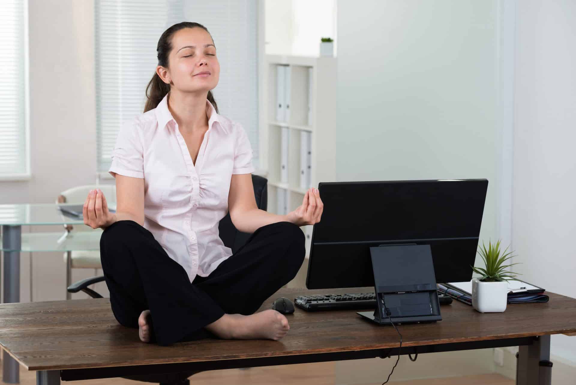 An entrepreneur meditating in front of a computer.
