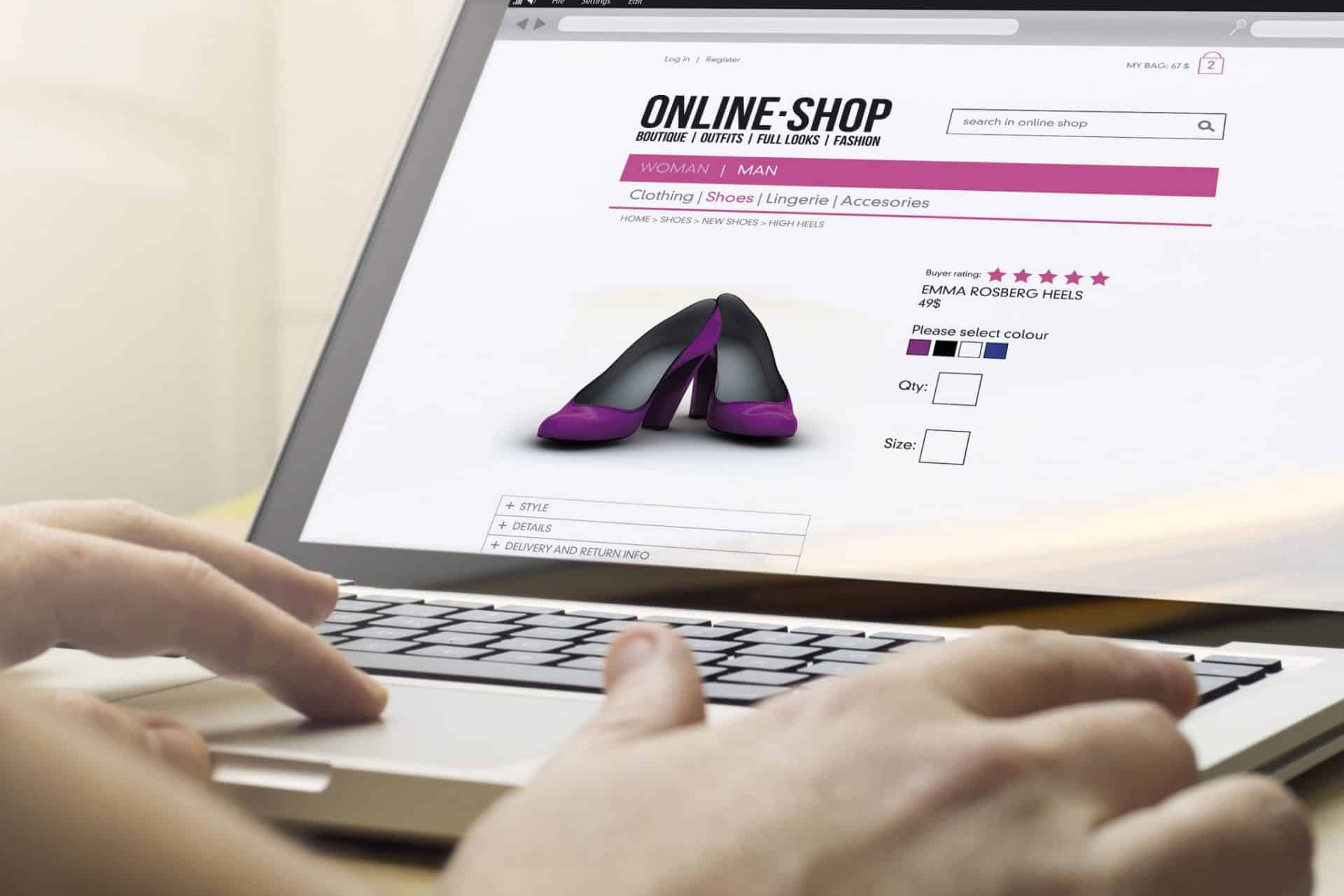 A person using a laptop with a purple shoe on the screen in an Ecommerce Store.