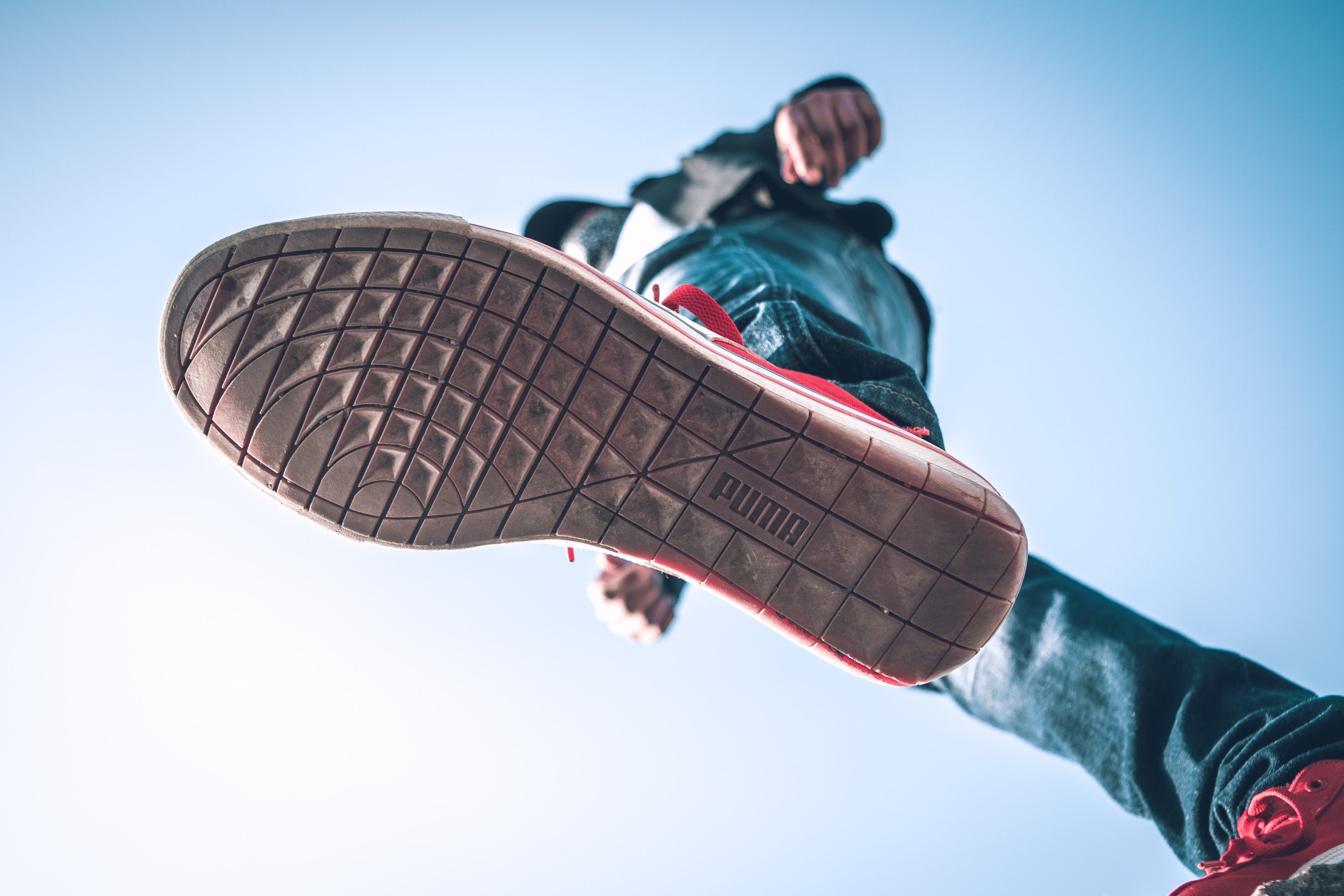 A person creating a strong brand voice while jumping in the air with a pair of sneakers.